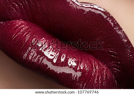 Close-Up Of Woman\'S Lips With Bright Fashion Dark Red Glossy Makeup. Macro Lipgloss Cherry Make-Up. Sexy Kiss