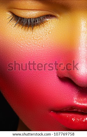 Beauty close-up portrait of beautiful woman model face with magic creative fashion multicolored make-up. Face painting, cosmetics, beauty and makeup.