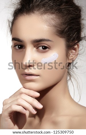 Make-up & cosmetics. Beauty portrait of beautiful woman model face with skin foundation base on light background