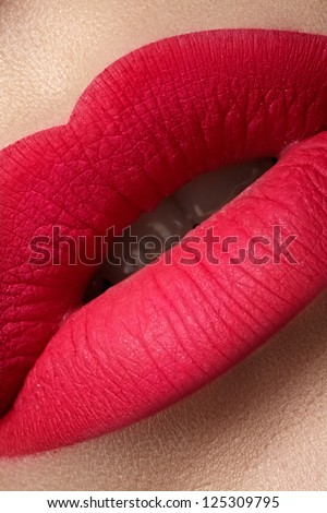 Close-up of beautiful full woman\'s lips with bright fashion mat pink makeup. Vertical macro shot with magenta frosted lip make-up