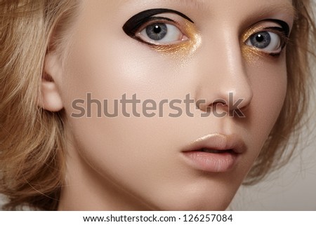 Beauty close-up portrait of beautiful young woman model face with clean skin. Wellness, skincare and bright black liner and gold make-up
