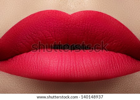 Close-up of beautiful full woman\'s lips with bright fashion mat pink makeup. Horizontal macro shot with magenta frosted lip make-up