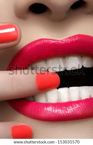 Close-up of woman\'s lips with fashion hot pink lipstick makeup. Beauty macro sexy make-up with bright magenta color on nails.