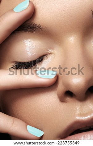Make-up & cosmetics, manicure. Close-up portrait of beautiful woman model face with clean skin on white background. Natural skincare beauty, clean soft skin, manicure. Suntan girl with sky blue nails