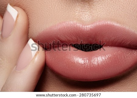 Close-up of full woman's lips with natural light makeup. Beauty macro sexy female mouth and french manicure on nails. Naturel tender look