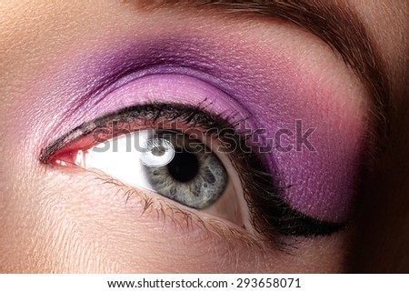 Cosmetics & make-up. Beautiful female eye with sexy black liner and bright purple makeup. Fashion classic arrow shape on woman\'s eyelid. Chic evening make-up