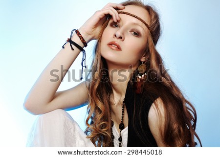 Bohemian woman in spring and summer clothes with beautiful accessories, natural make-up and shiny hairstyle. Fashion hippie style. Long curly hair.