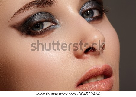 Beautiful woman face with bright make up eye with sexy liner makeup. Fashion big arrow shape on woman\'s eyelid. Chic evening make-up, healthy face