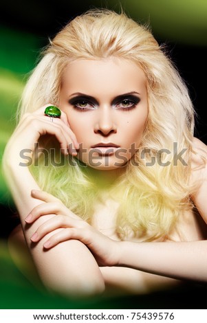 stock photo : Alluring blond woman model with big ring in magic green mist. Glamour and fashion style. Real lights effect: mixed light with long exposure.
