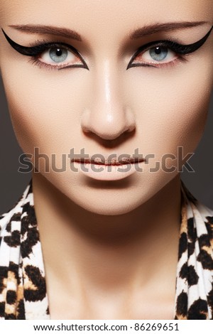 Fashion woman model with glamour make-up, cat eye liner makeup and scarf with leopard print. Vamp, wild cat style