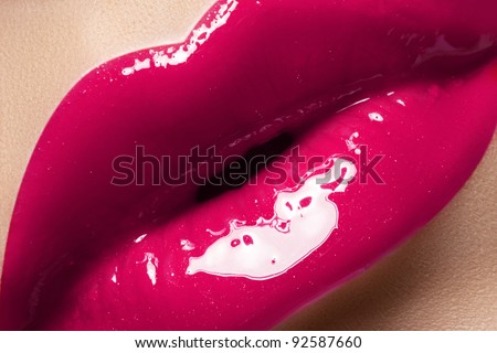 Sexy pink wet lip makeup. Highly saturated color. Close-up of beautiful full lips with water gloss make-up effect