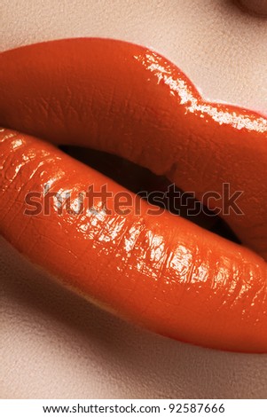 Fashion bright coral lip make-up. Glamour macro shot of beautiful full lips with hot orange lipstick makeup