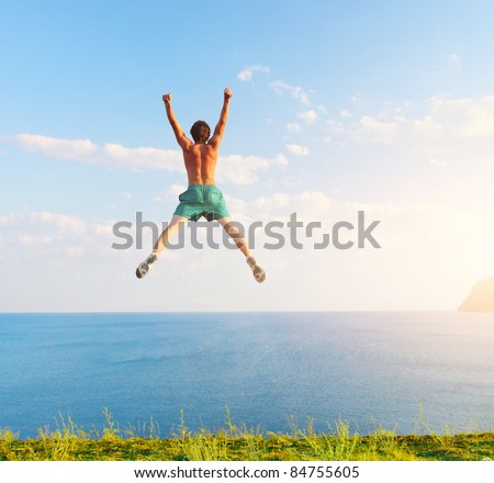 Young jumping man with sea and sky on the background