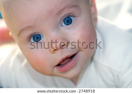 baby infant with big blue eyes smiling