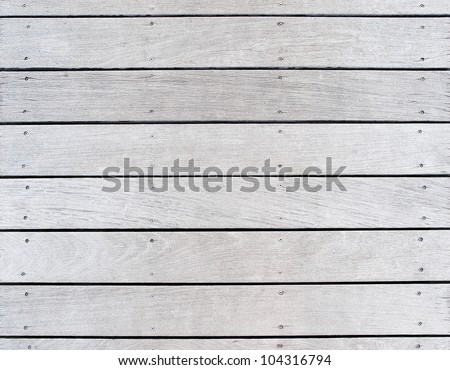 A boat dock\'s old weathered and faded wood decking. Features the pattern and texture of the wood and hardware fasteners.
