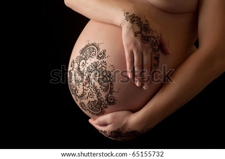 stock photo : A photo of henna tattoo paste on a woman's hands and pregnant belly