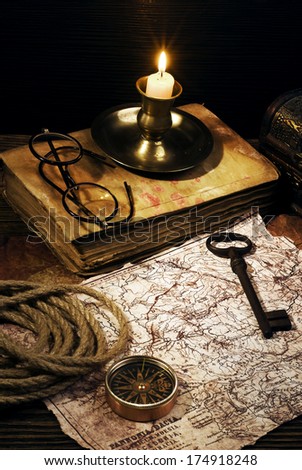 ancient books with candle and Compass on the old paper background