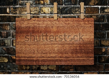 old wooden sign on the background of a brick wall