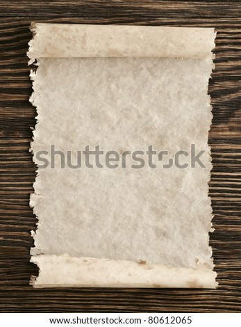 Old paper scroll on a wood background