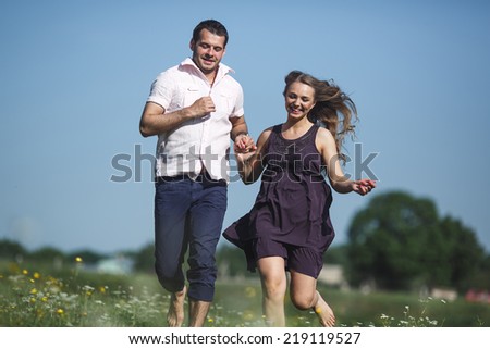 Couple running in field and have fun