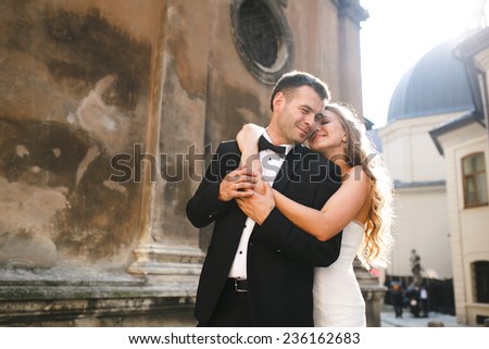 Bride hugging groom from behind