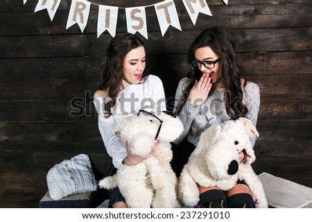 Two charming girls playing with Christmas toys