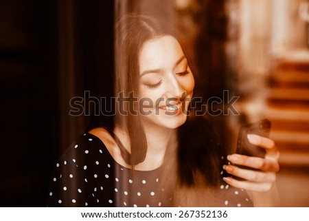 Beautiful girl works with  technologise on the phone and smiles