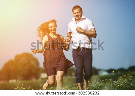 Couple running in field and have fun