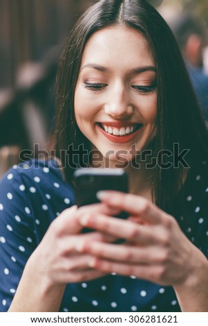 Beautiful girl works with technologise on the phone and smiles