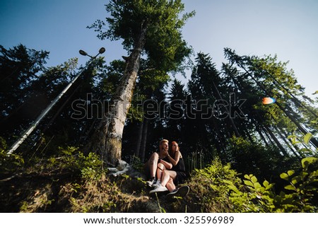 beautiful couple and a dog have a rest in the forest