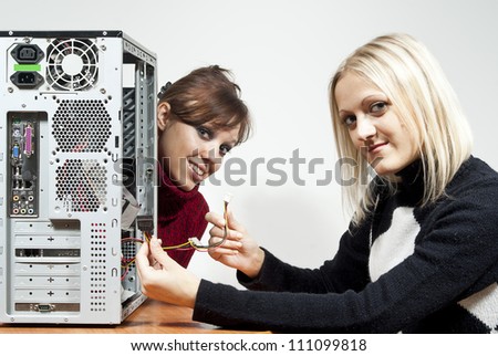 Two girls repair the system unit