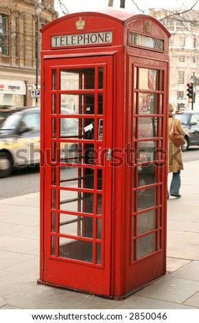 an old telephone box in London, with a london taxi in the background with motion blur on the taxi