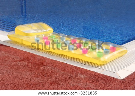 a lilo or inflatable air bed on the side of a swimming pool