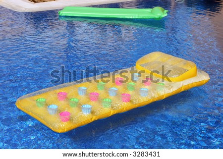 a lilo or inflatable air bed on the side of a swimming pool