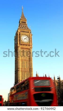 a london bus travels past big ben, with motion blur on the bus