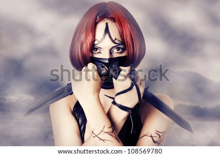 Fantasy style - red haired woman with dark creative make up, mask on her face and two combat knifes