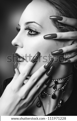 Woman face with fashion make up, false lashes and long finger nails