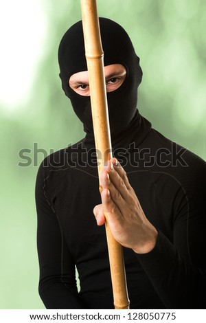 Close up portrait of male ninja in black mask covered his face