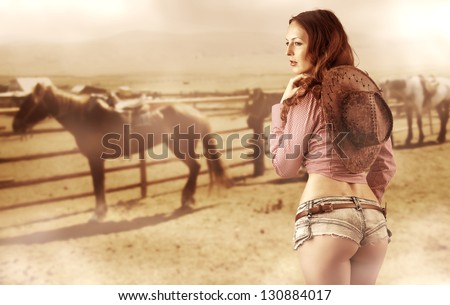 Sexy cowgirl with brown hat and sexy buttocks in jeans shorts