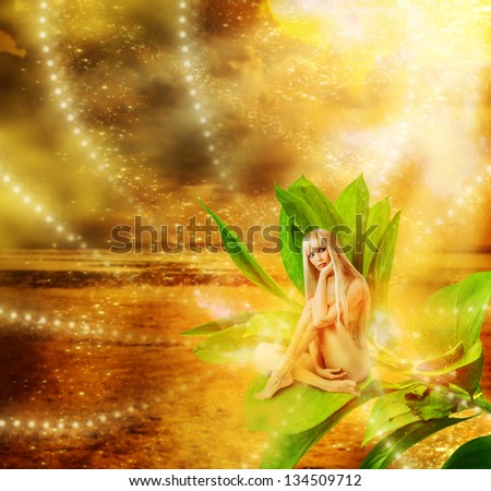 Sexy woman pixie with flower on hand  sitting on green grass in golden fantasy magic world