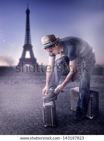 Young handsome casual man Traveler in a straw hat with old brown suitcase wearing dress read guide to Paris, France