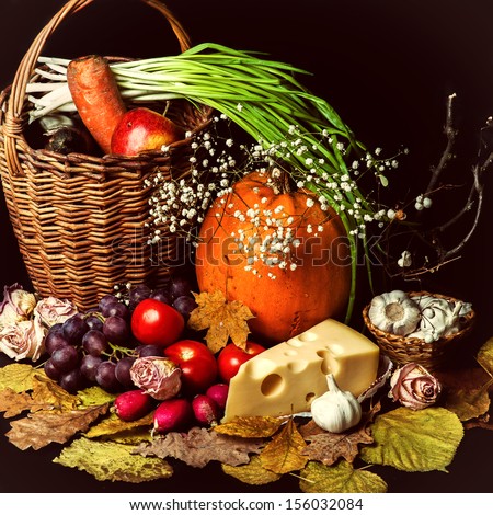 Beautiful autumn harvest of vegetables and leaves on black background