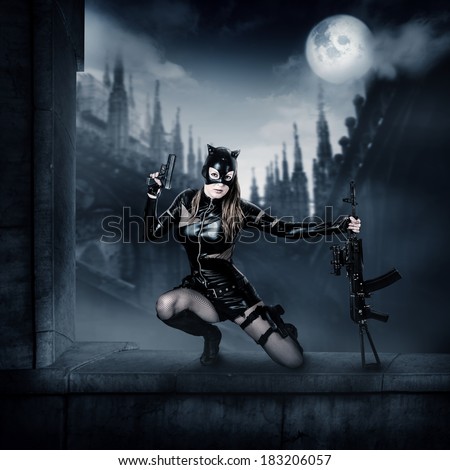 Fantasy. Military sexy woman in latex cat suit holding gun and automatic