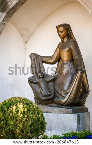Bronze statue of woman with child in arc in Cathedral of St. Florins Parish Church  in Vaduz, capital of principality Liechtenstein
