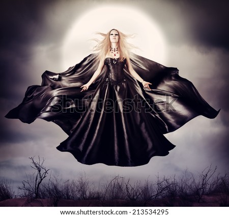 Beautiful woman - flying halloween witch in midnight outdoor about full moon with black developing cloak