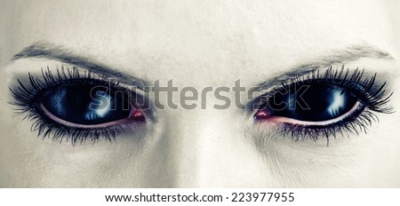 Evil black female alien, vampire or zombie eyes. dirt make up. Macro. Halloween theme