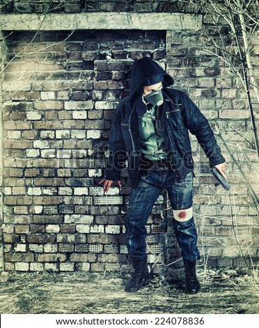 Environmental disaster. Post apocalyptic survivor in gas mask holding hand gun