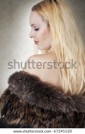 Fashion portrait of model woman. Rich blonde lady in fur coat back