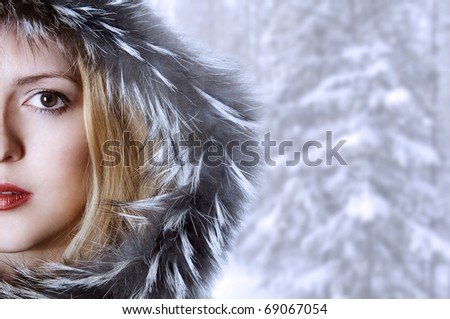 Fashion woman in winter fur hat. Half of face