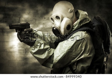 Post apocalypses world halloween concept. Portrait of man in gas mask with handgun